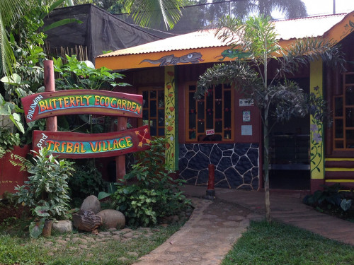 Entrance to the Butterfly Eco Garden and Tribal Village with wooden signage and traditional Filipino architecture in Puerto Princesa, Palawan