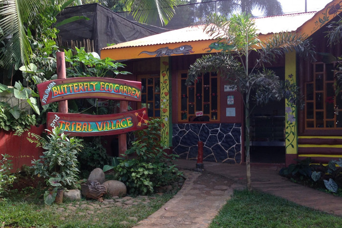 Entrance to the Butterfly Eco Garden and Tribal Village with wooden signage and traditional Filipino architecture in Puerto Princesa, Palawan