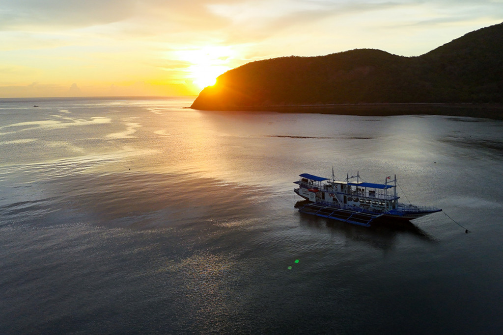 Expedition boat at anchor at sunset on the Palawan west coast